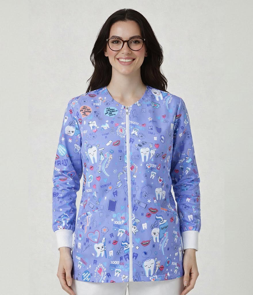 A woman wearing a light purple medical scrub jacket with a white zipper and a colorful dental-themed print of teeth, stethoscopes, and medical icons, set against a plain light gray background.