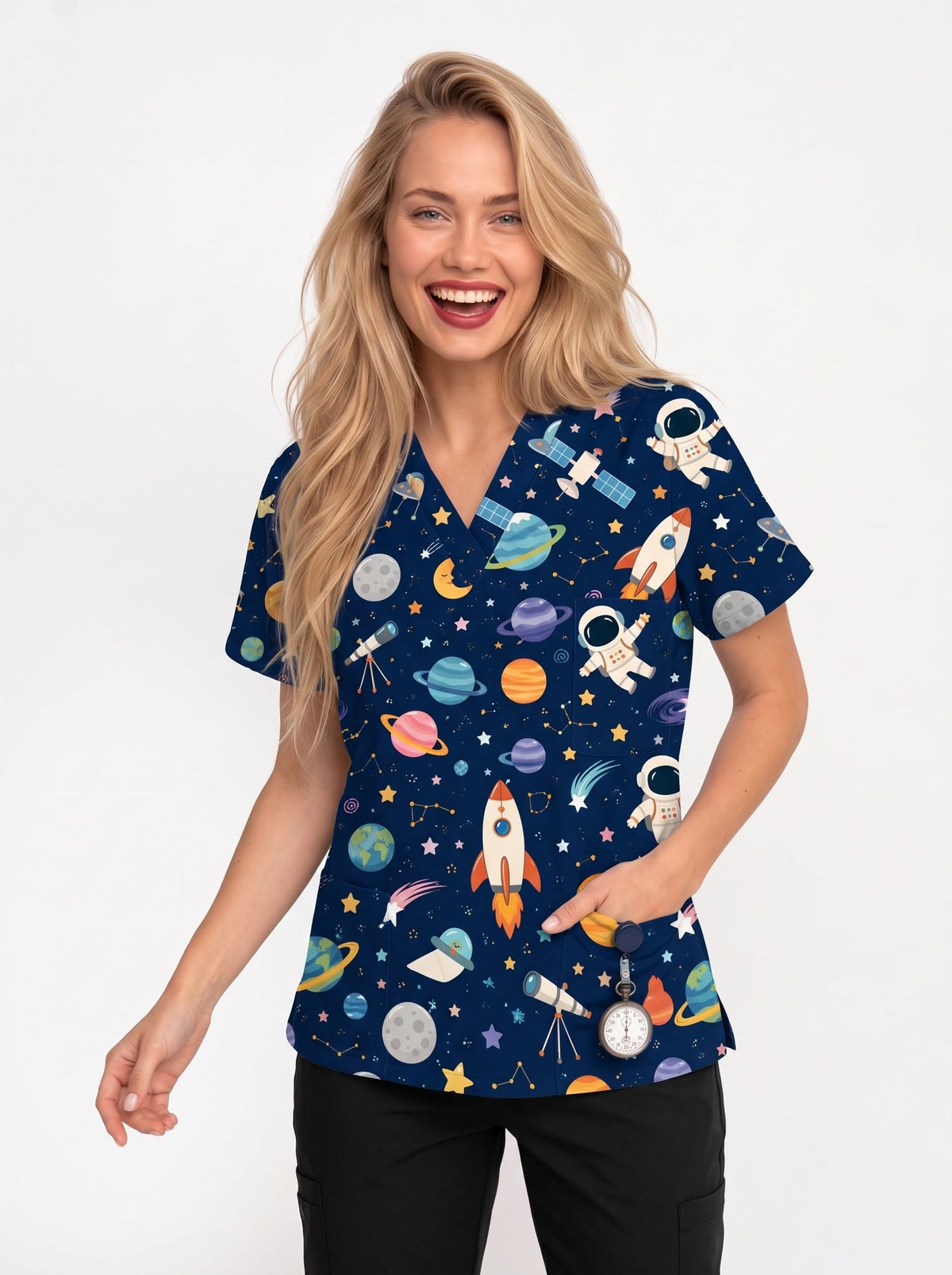 A smiling blonde woman wearing a navy blue V-neck scrub top with a colorful space-themed print of rockets, astronauts, planets, and stars, paired with black pants, against a plain white background.