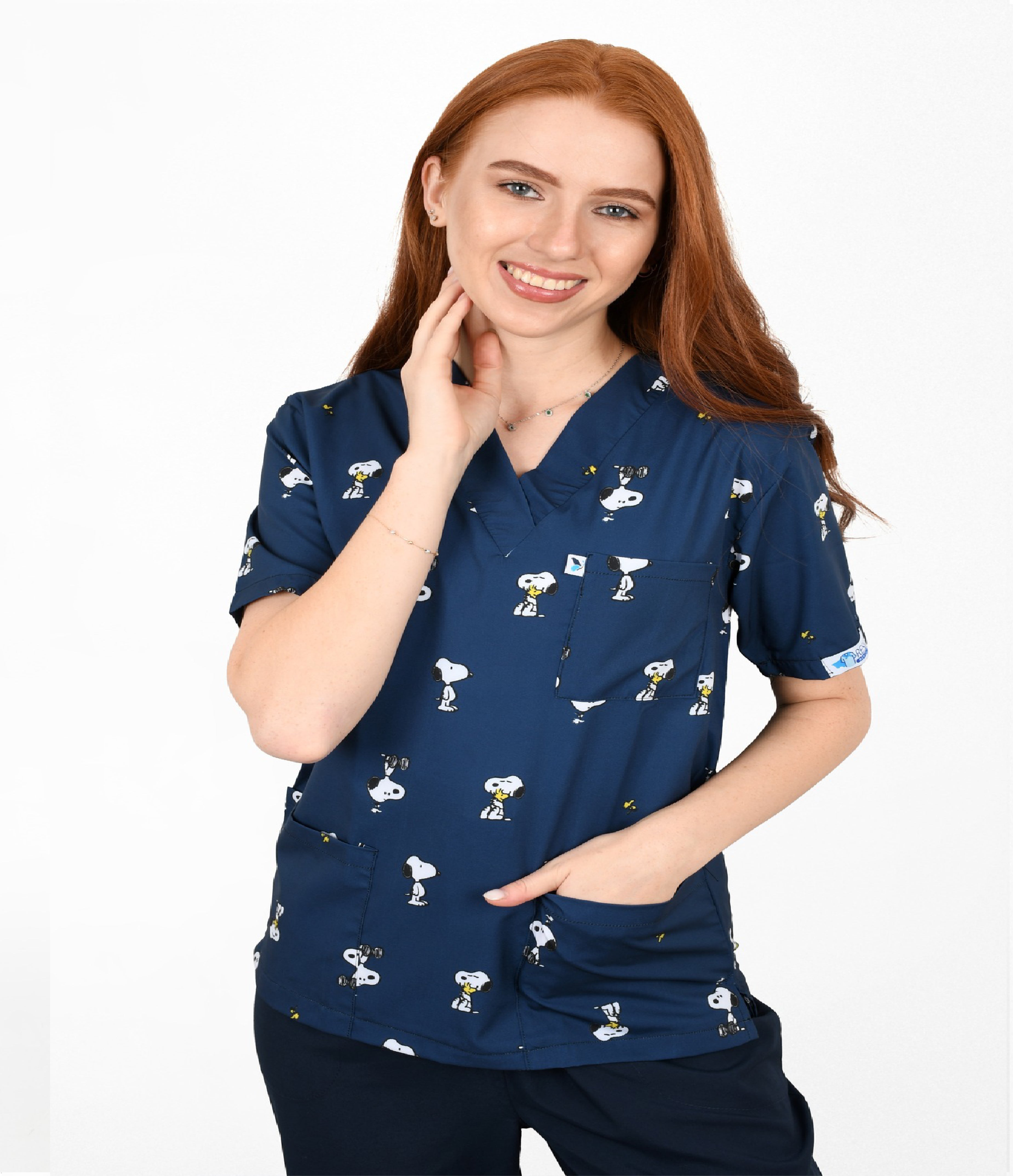 Healthcare professional in navy cartoon dog patterned scrub top with two front pockets, comfortable medical workwear.
