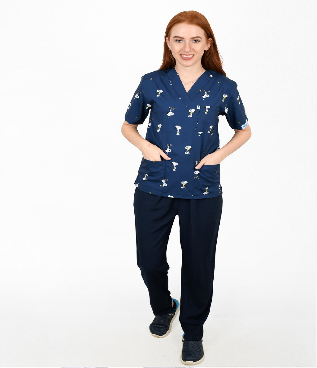 Woman wearing a navy blue scrub set with white patterns on a white background