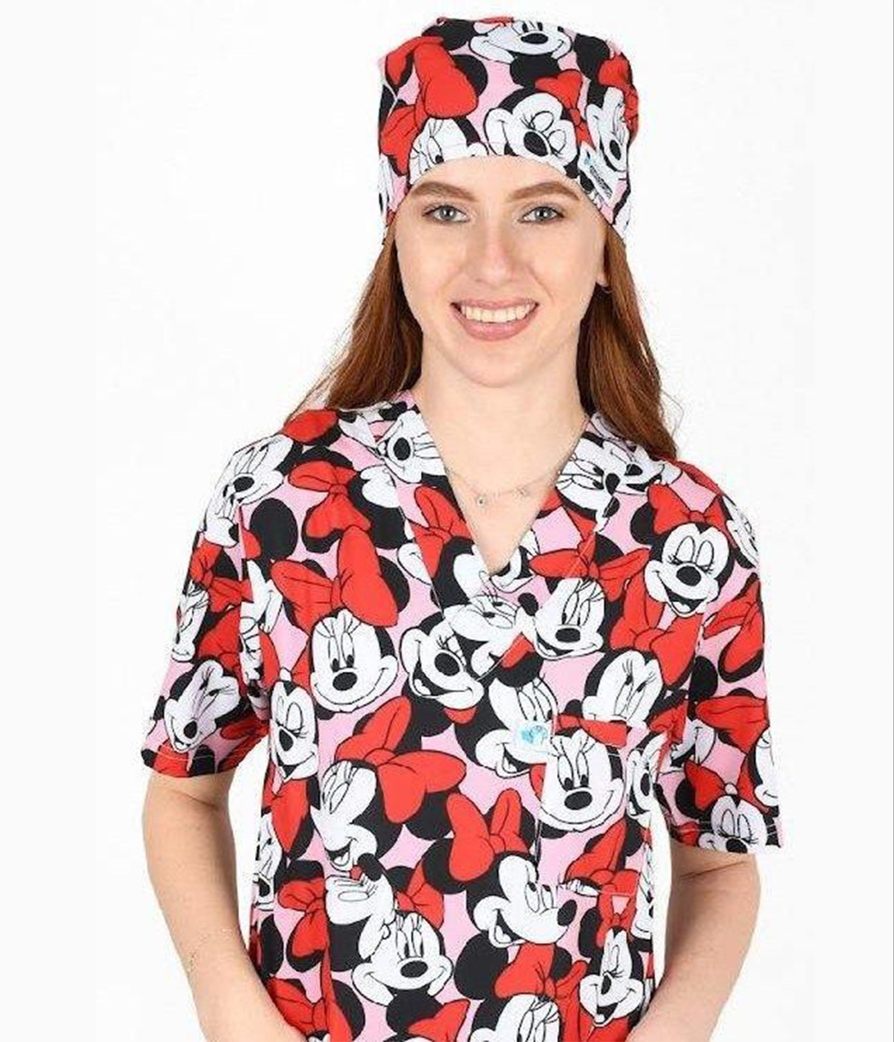 Person wearing a Minnie Mouse-themed scrub top and cap on a white background
