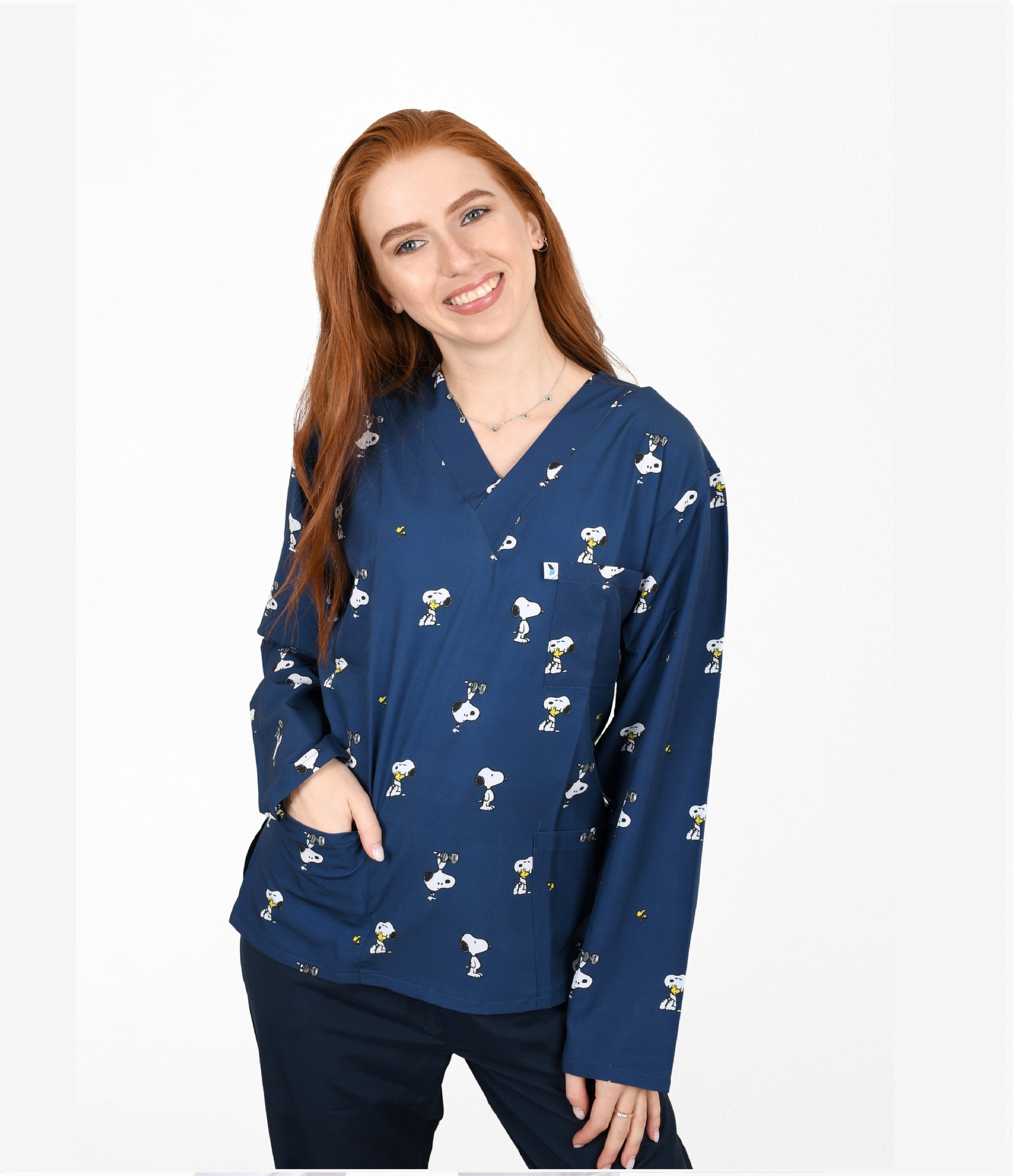 Female nurse wearing navy blue cartoon dog print scrub top with front pockets, cute veterinary themed medical uniform.